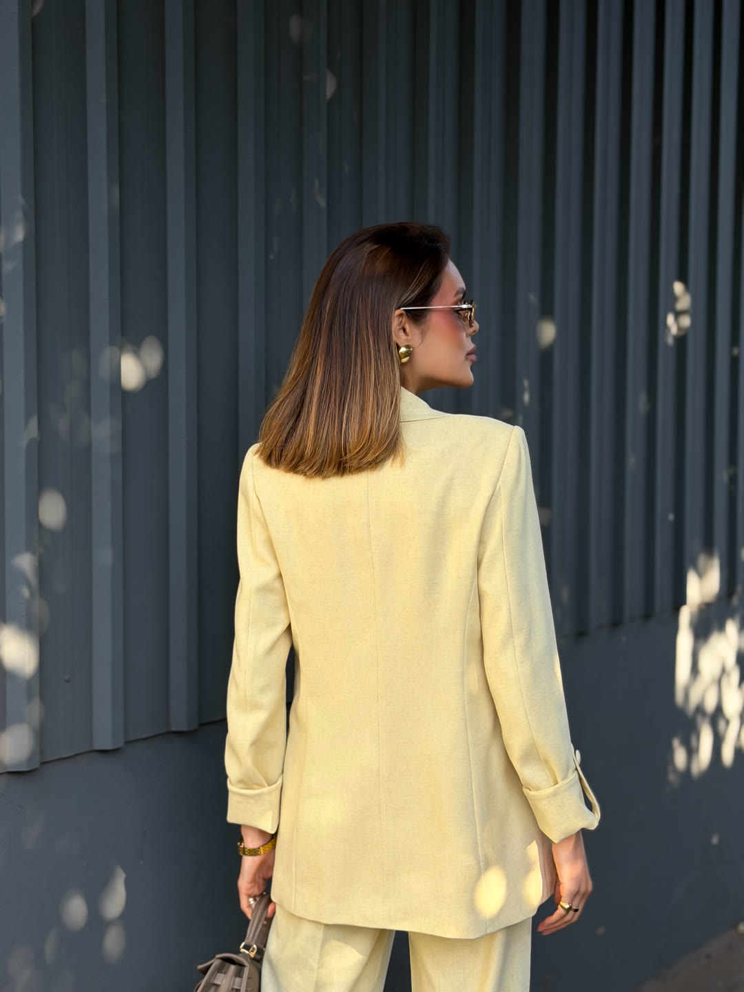 Blazer de alfaiataria amarelo-manteiga visto de costas — conjunto da curadoria ZAYA Boutique, Batel, Curitiba