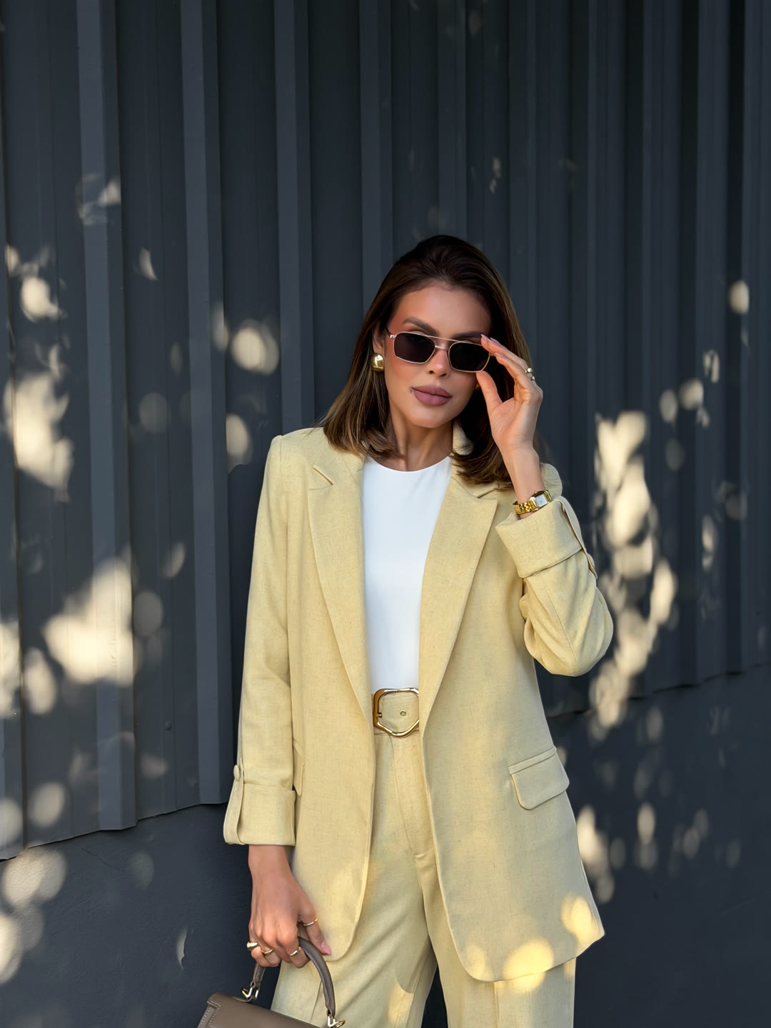 Blazer amarelo-manteiga com camiseta branca e óculos escuros — look executivo leve da ZAYA Boutique, Curitiba