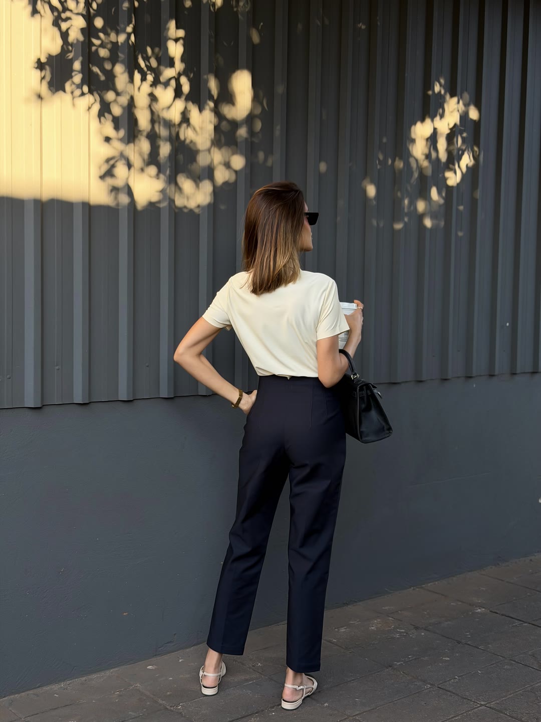 Calça azul-marinho de alfaiataria vista de costas com camiseta creme — ZAYA Boutique, Batel, Curitiba