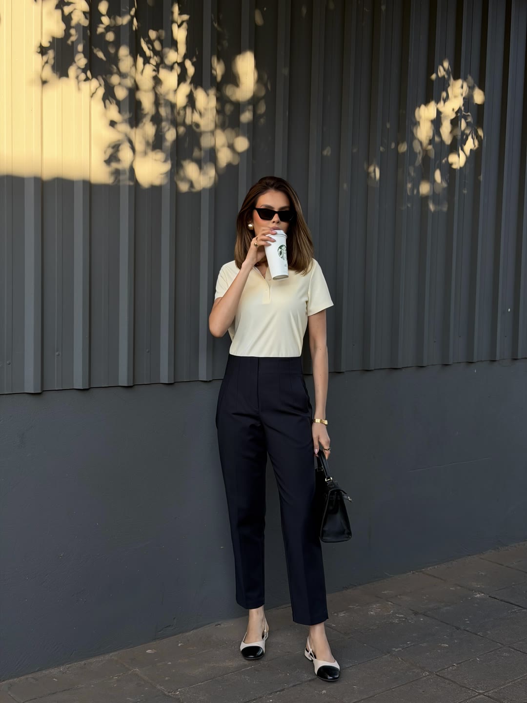 Look casual-chique com camiseta creme, calça azul-marinho e café — ZAYA Boutique, Curitiba