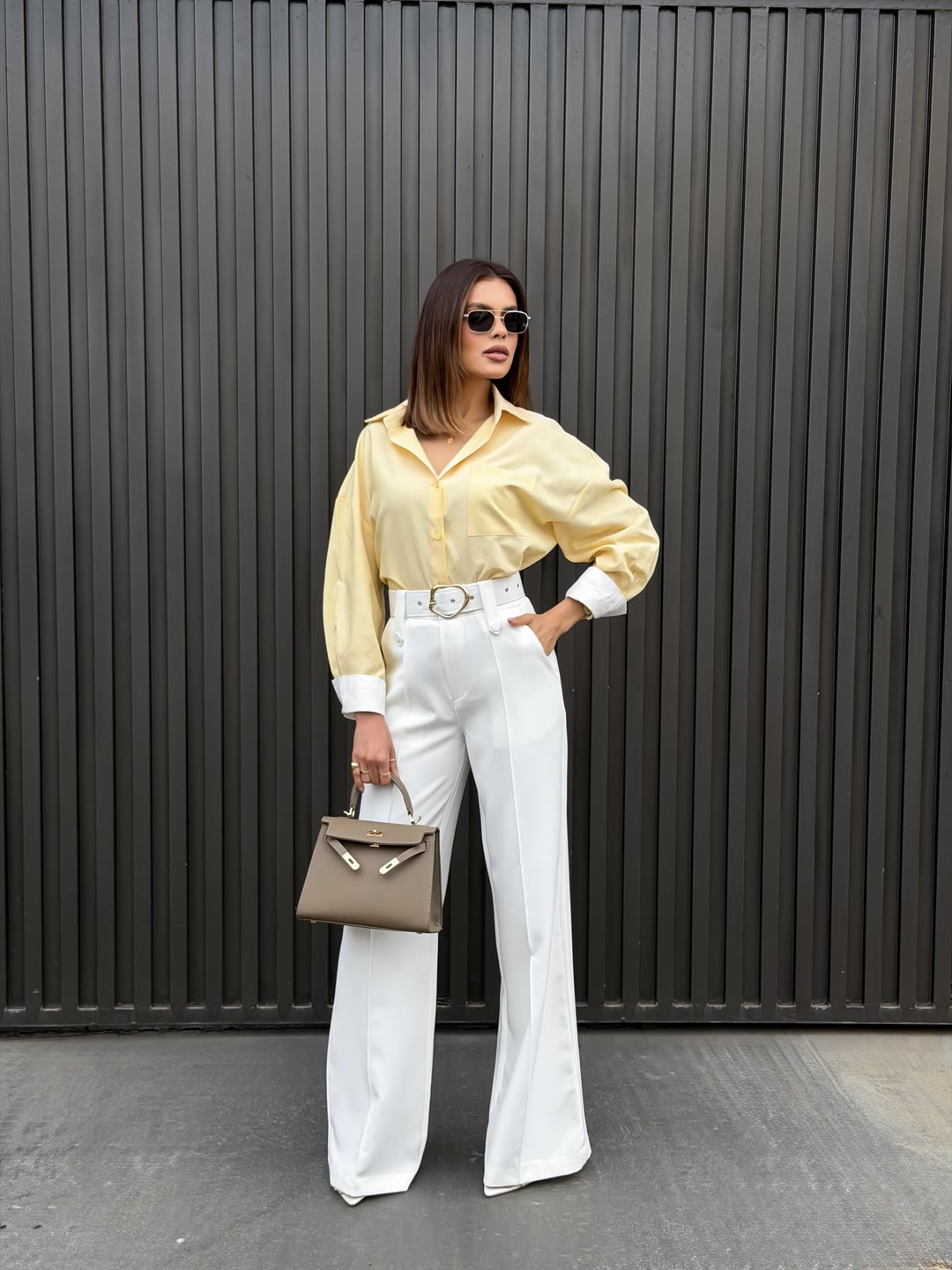 Camisa amarela oversized com calça pantalona branca de cintura alta e cinto de fivela — ZAYA Boutique, Batel